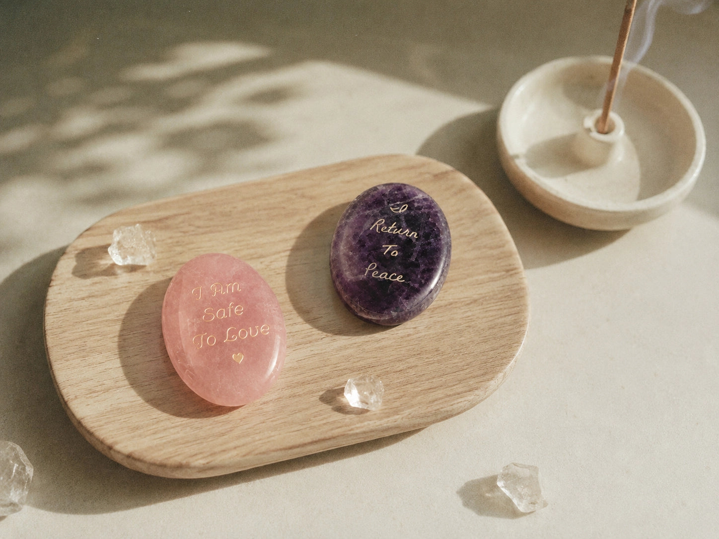 Two engraved KOVA stones arranged on a wooden tray