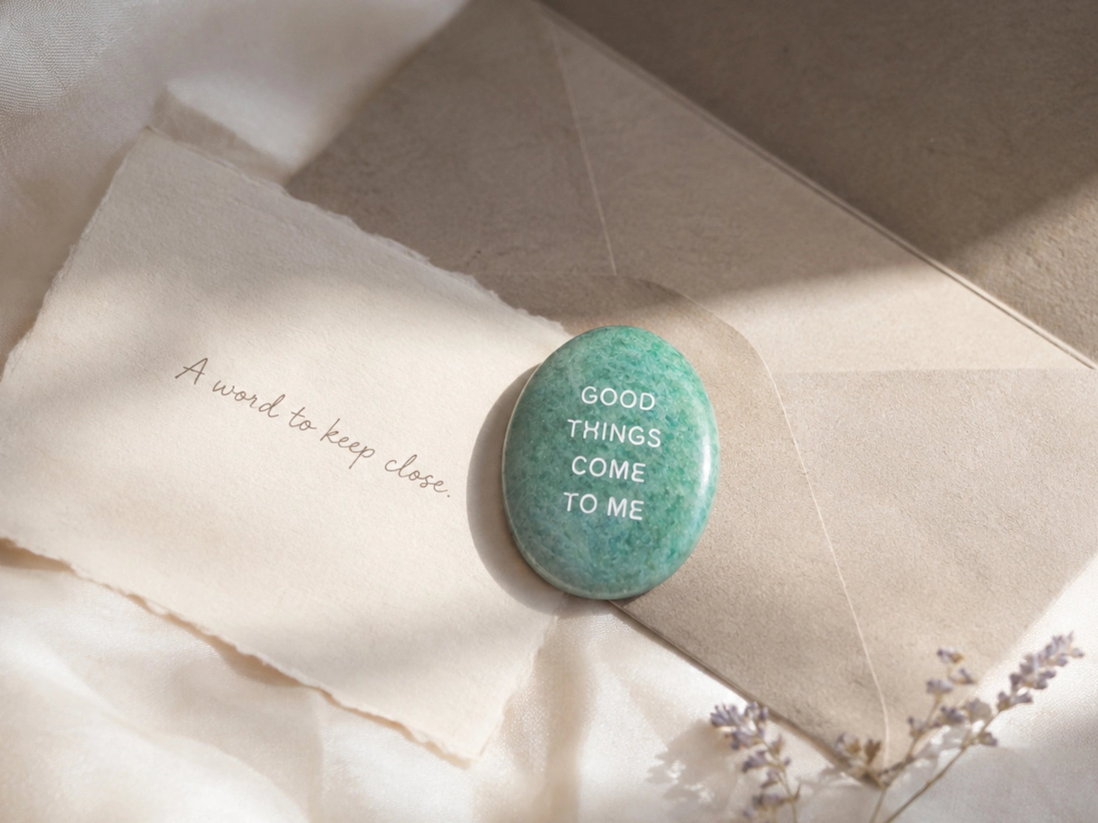 An engraved KOVA stone resting on a handwritten note and envelope